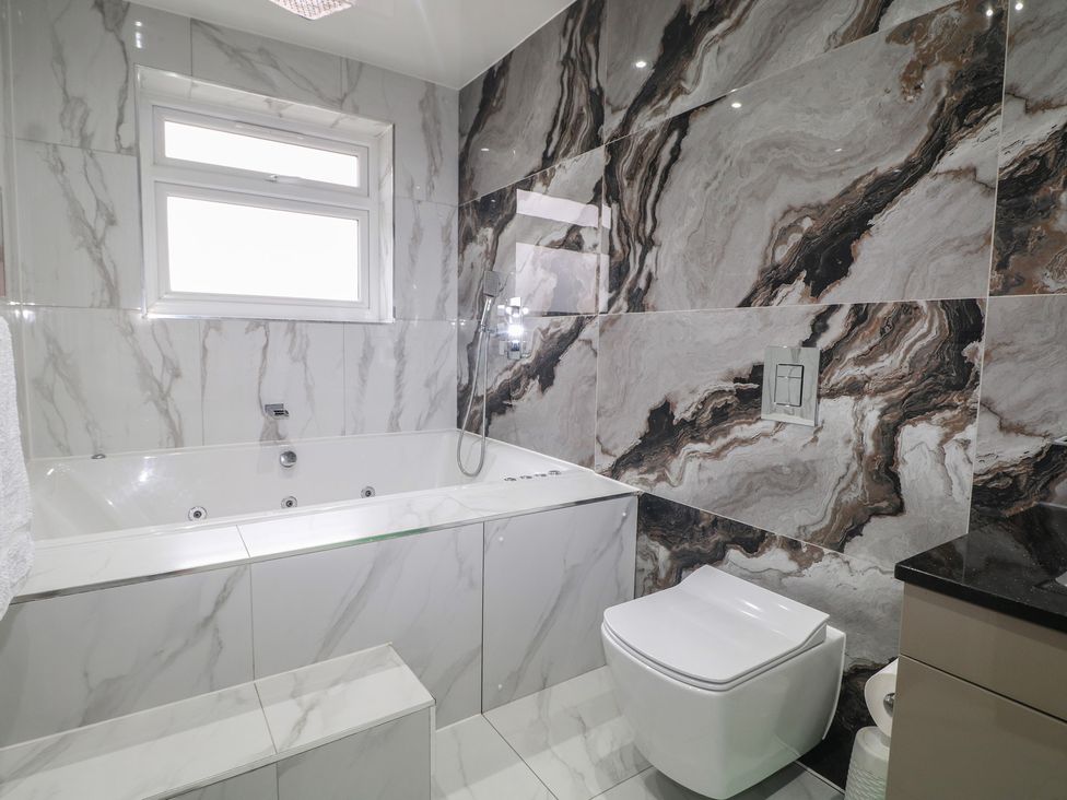 A bathroom with a bathtub and toilet at Falcon Bal House