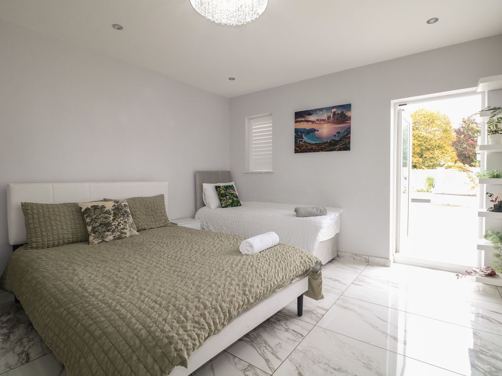 A bedroom with two beds and a door leading outside at Falcon Bal House