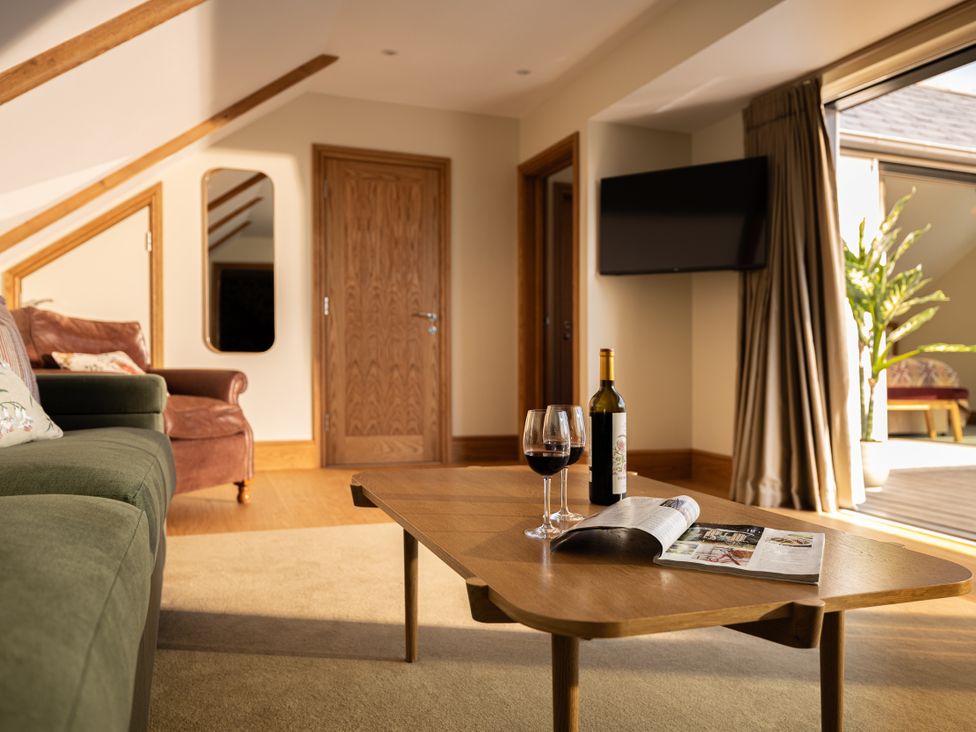 A living room with a coffee table and a wine bottle at Trevean in Mullion