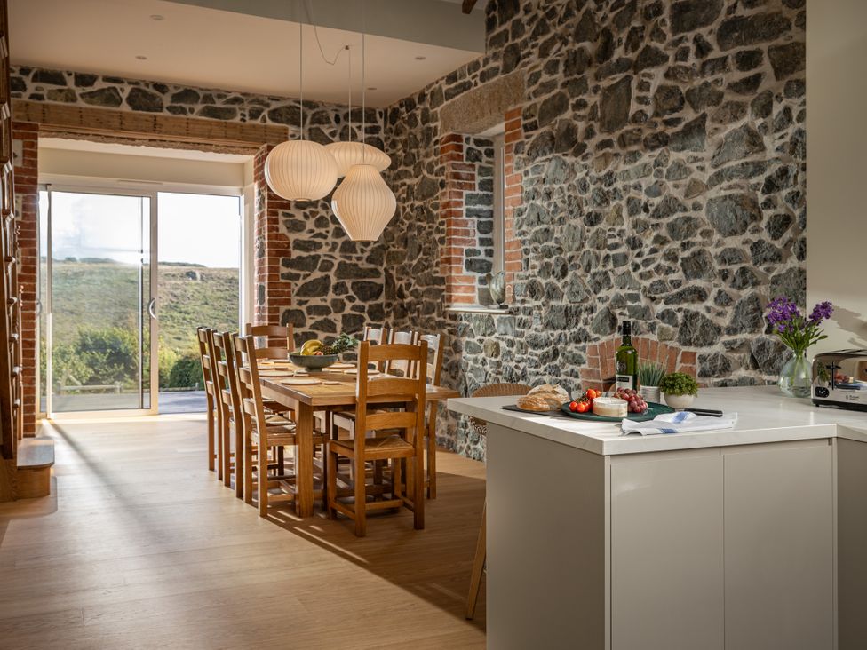 A kitchen with a dining table and chairs at Trevean in Mullion