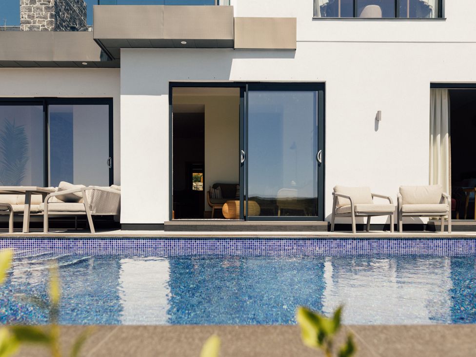 An outdoor area with a pool and seating at Trevean in Mullion