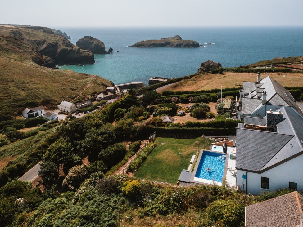 A view of a pool and garden by the sea at Trevean in Mullion