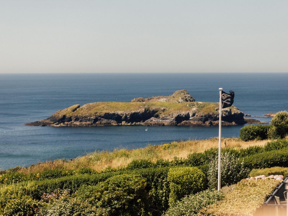 A view of an island and ocean with greenery at Trevean in Mullion