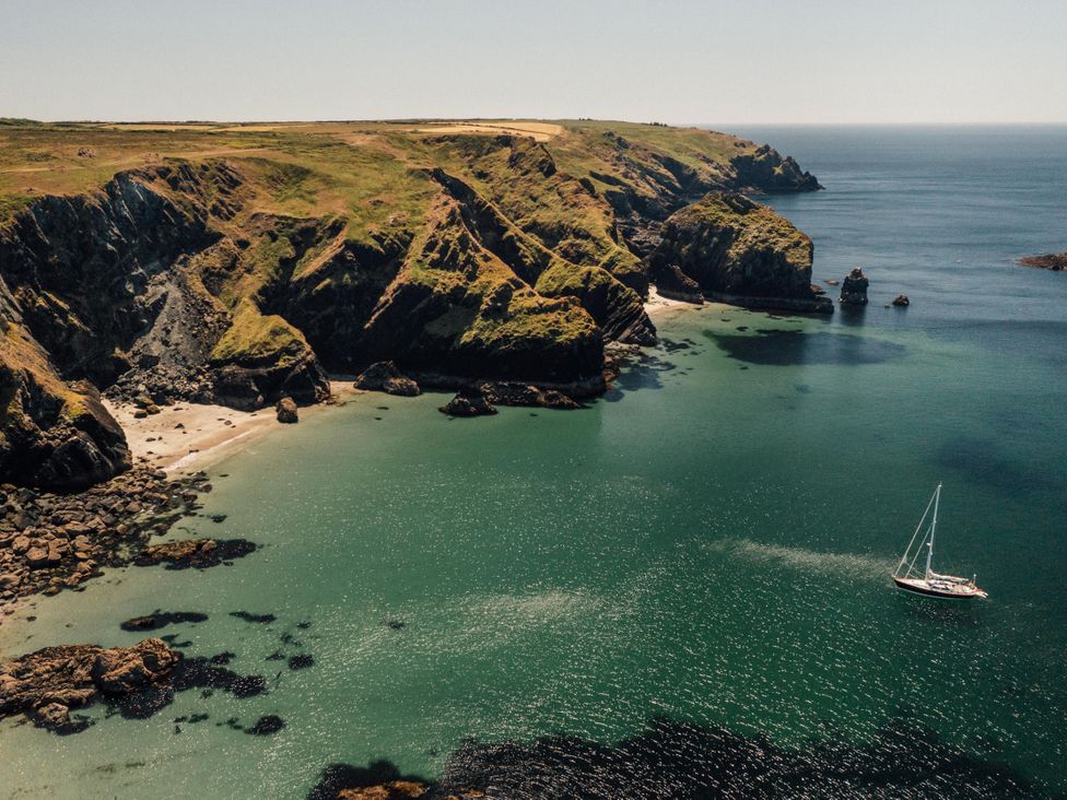 A coastal scene with a boat near the shore at Trevean in Mullion