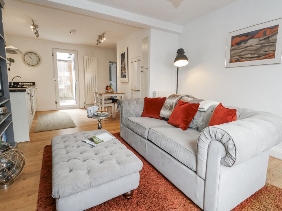 A living room with a sofa and dining area at Fisherman’s Cottage