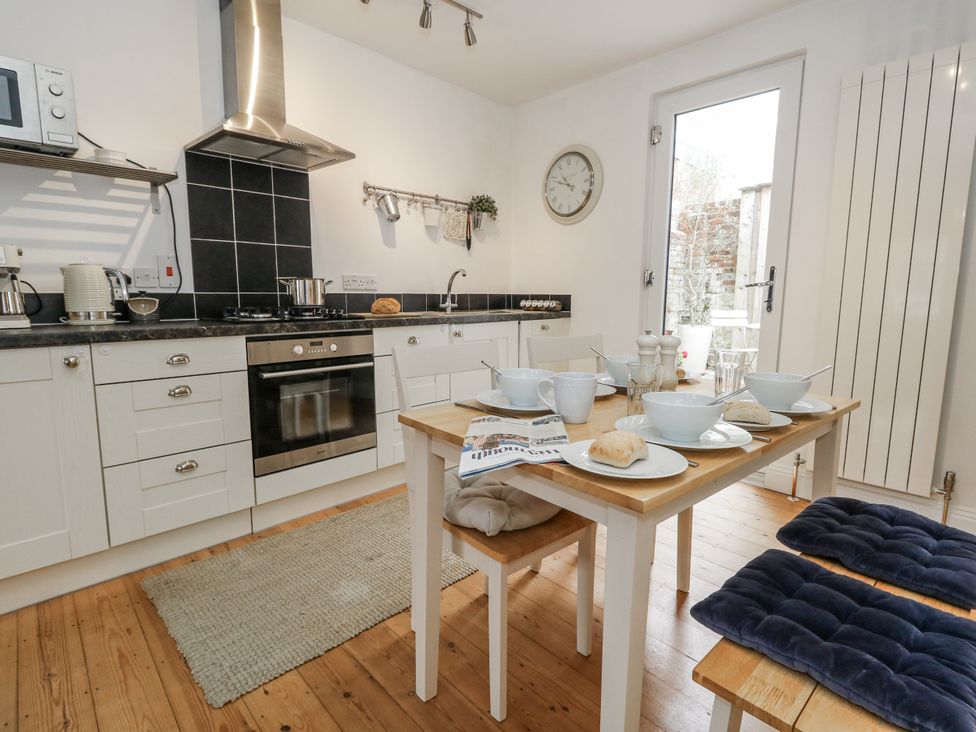 A kitchen with a dining table and cooking appliances at Fisherman’s Cottage