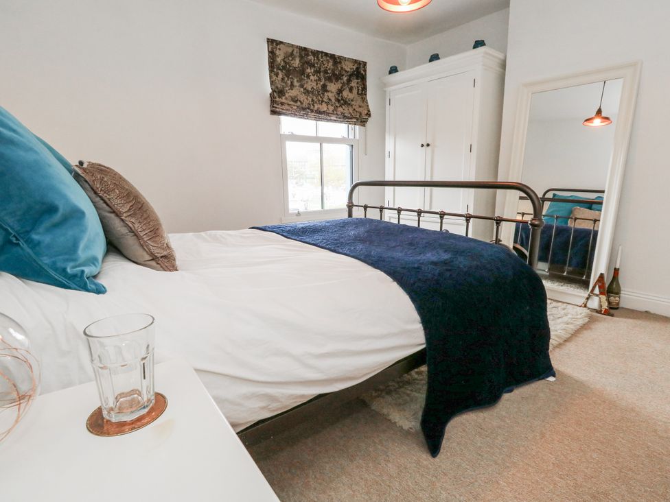 A bedroom with a bed and wardrobe at Fisherman’s Cottage