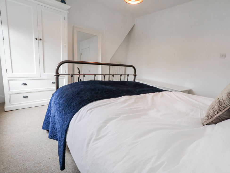 A bedroom with a bed and wardrobe at Fisherman’s Cottage