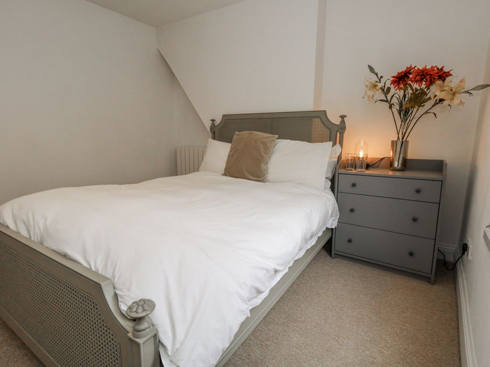 A bedroom with a bed and bedside table at Fisherman’s Cottage