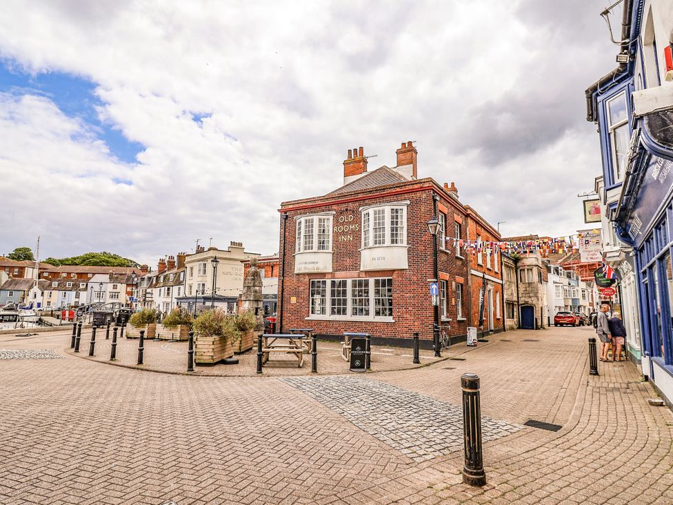 A pub building on a street with flags and lampposts at Fisherman’s Cottage in 