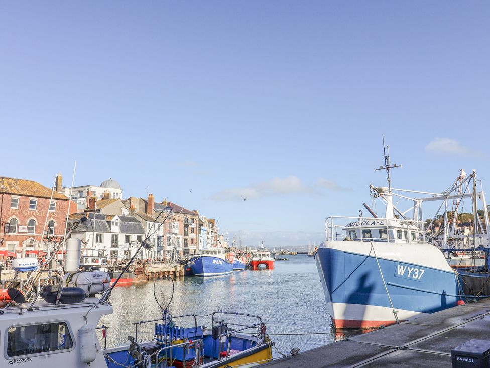 A harbor with boats and buildings by the water at Fisherman’s Cottage