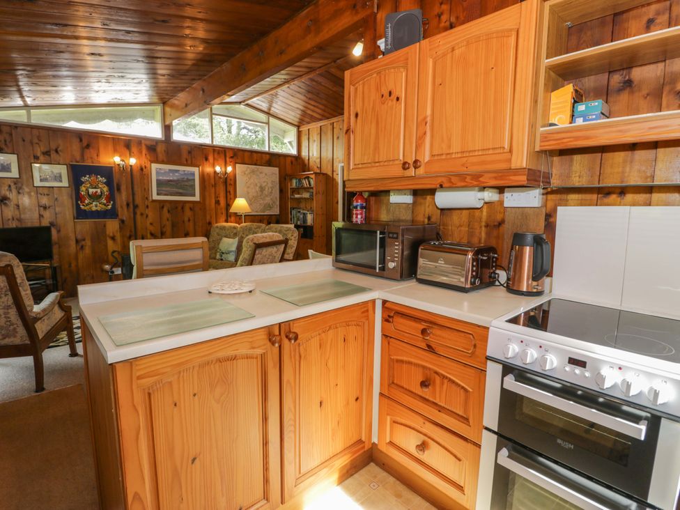 A kitchen with wooden cabinets and appliances at Ty Bedwen in Dinas Mawddwy