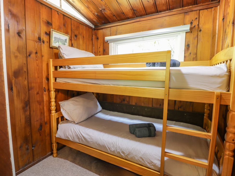 A bedroom with a bunk bed and window at Ty Bedwen in Dinas Mawddwy