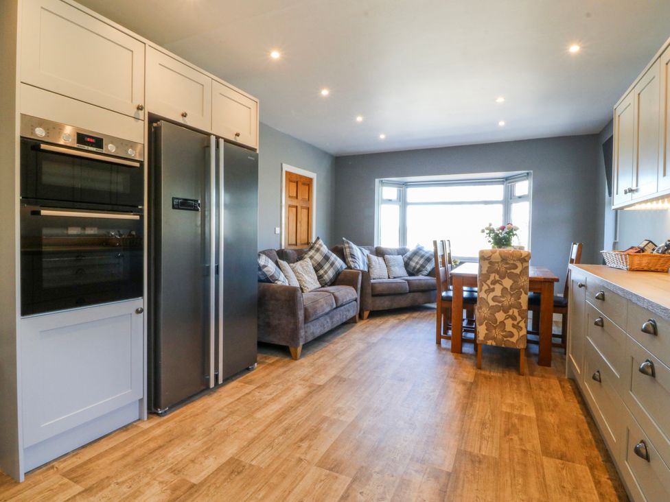 A kitchen with appliances and seating at Tirionfa in Talsarnau