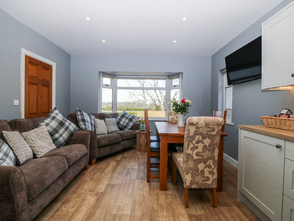 A dining room with a sofa and dining table at Tirionfa in Talsarnau