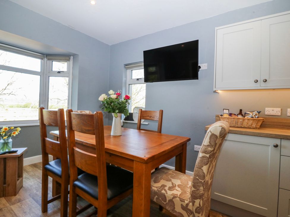 A dining room with a table and chairs at Tirionfa in Talsarnau