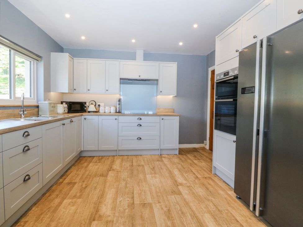 A kitchen with cabinets and appliances at Tirionfa in Talsarnau