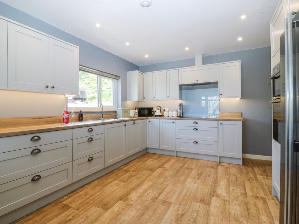 A kitchen with cabinets, sink, and countertop at Tirionfa in Talsarnau