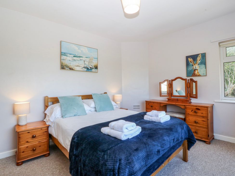 A bedroom with a bed and a dresser at Tirionfa in Talsarnau