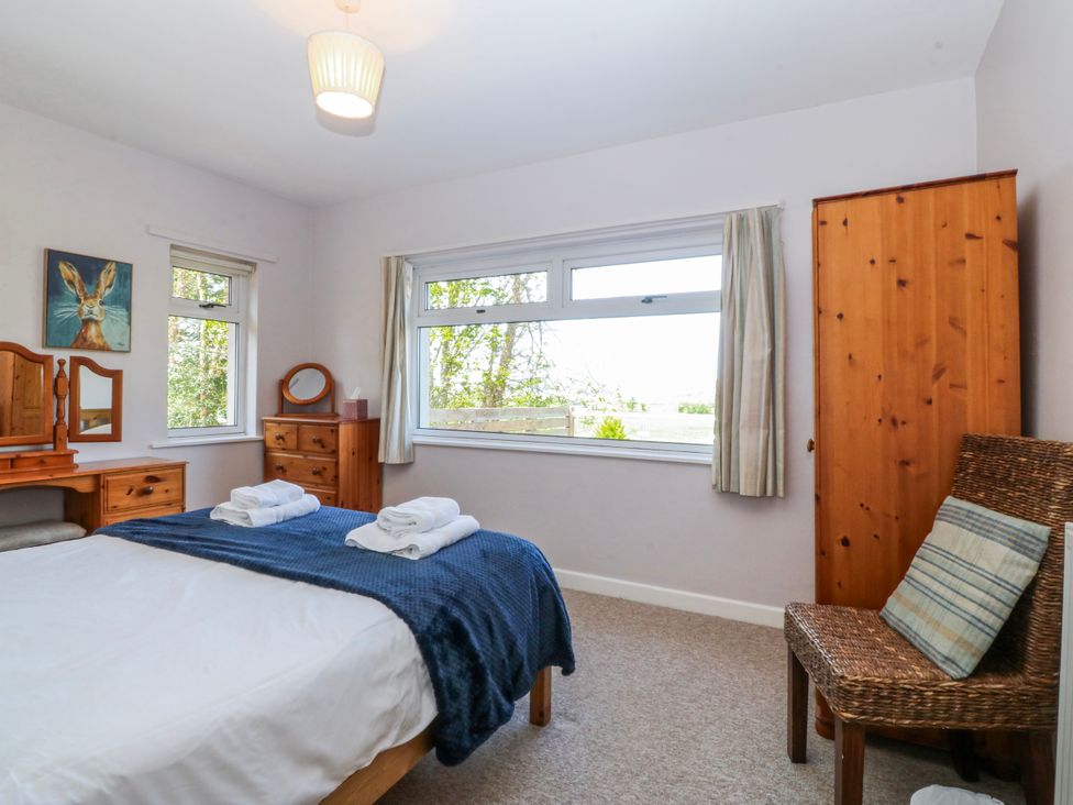 A bedroom with a bed and dresser at Tirionfa in Talsarnau
