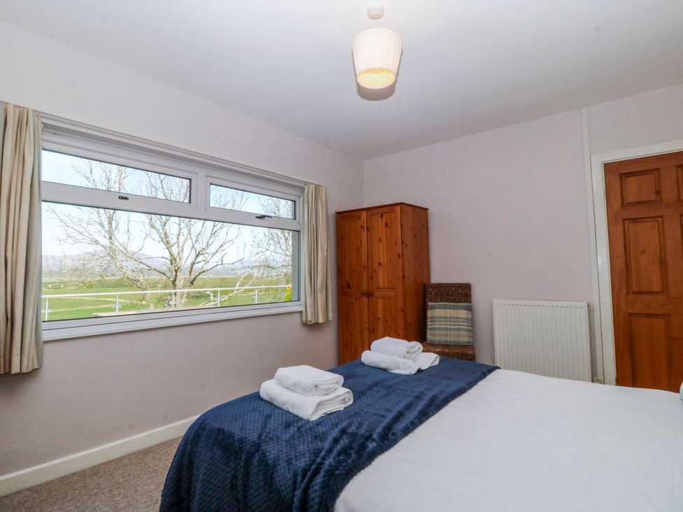 A bedroom with a bed and towels on it at Tirionfa in Talsarnau
