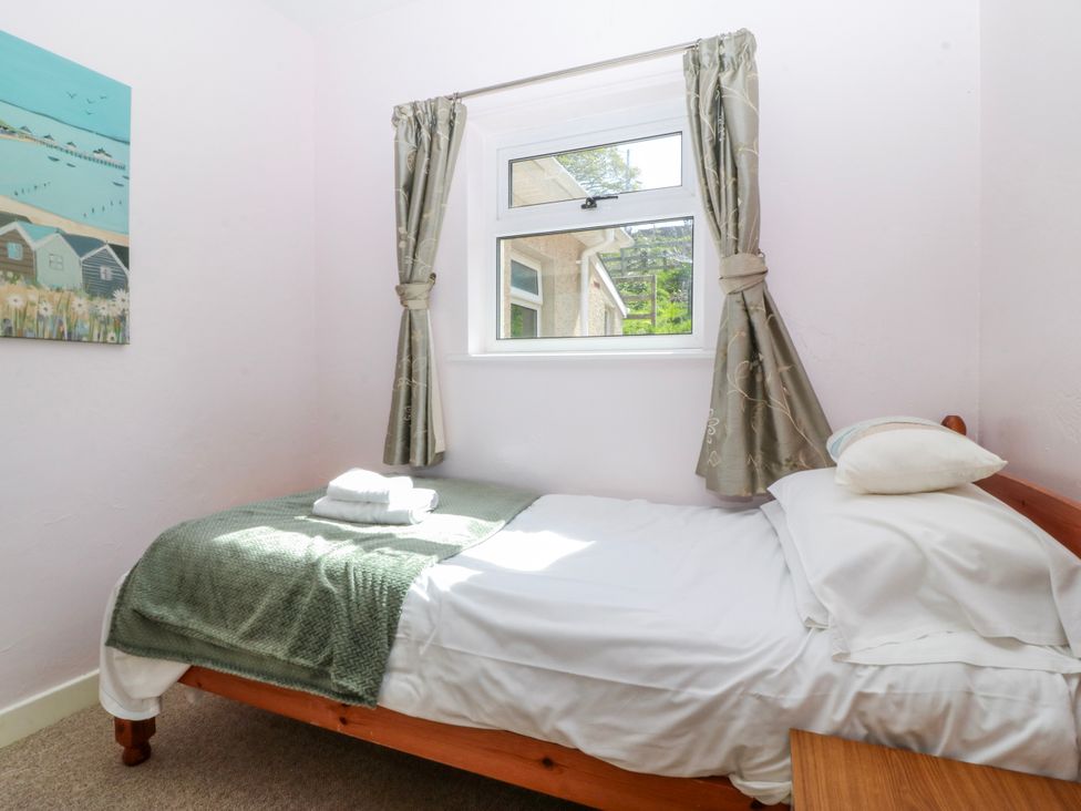 A bedroom with a bed and window at Tirionfa in Talsarnau