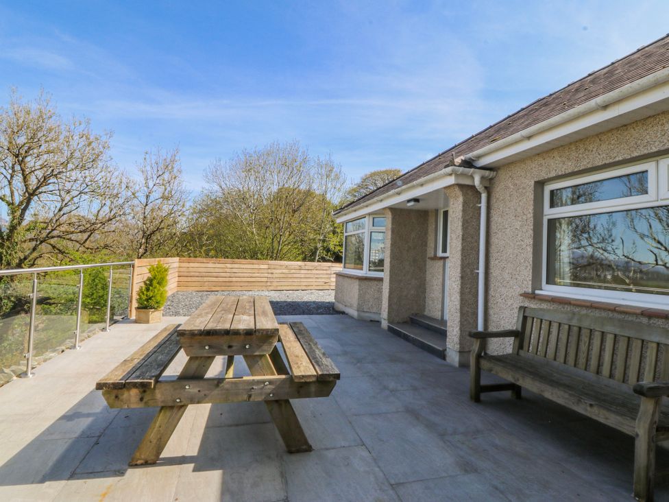 An outdoor space with a table and benches at Tirionfa in Talsarnau