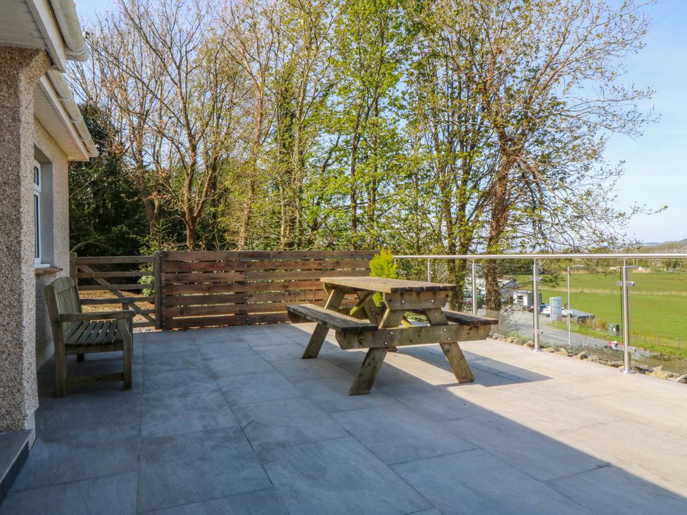 A patio area with a picnic table and benches at Tirionfa in Talsarnau