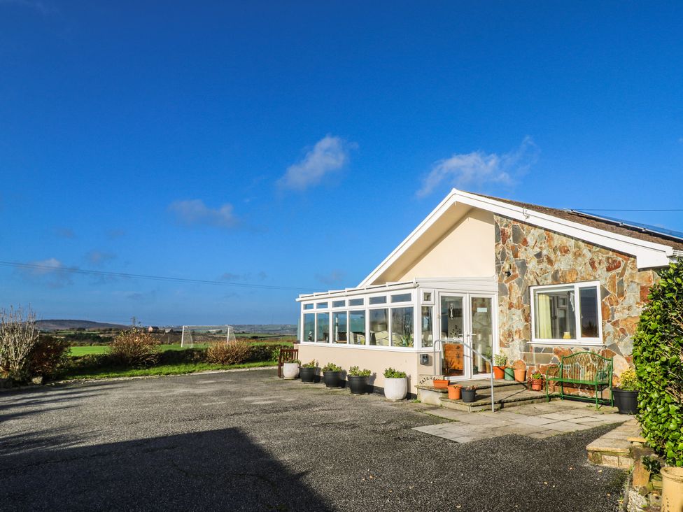 A house with a stone wall and a glass conservatory at Tataramoa near Falmouth