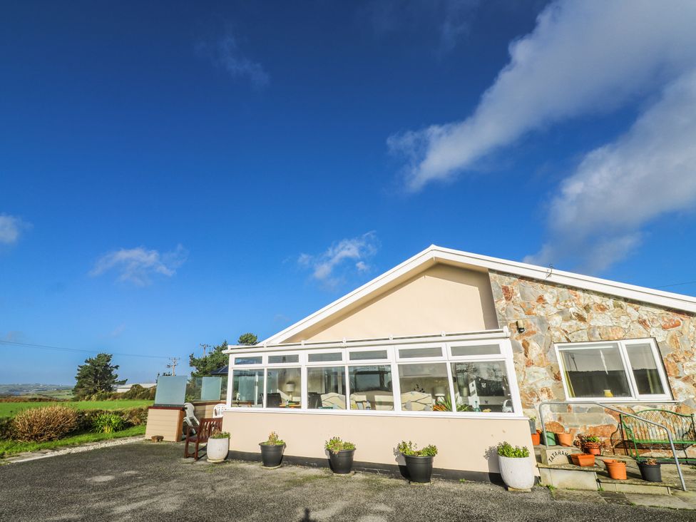 A sunroom with large windows and plant pots at Tataramoa near Falmouth