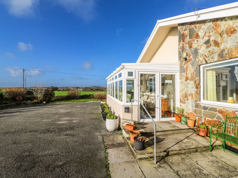 An exterior view of a house with a stone wall and planters at Tataramoa near Falmouth