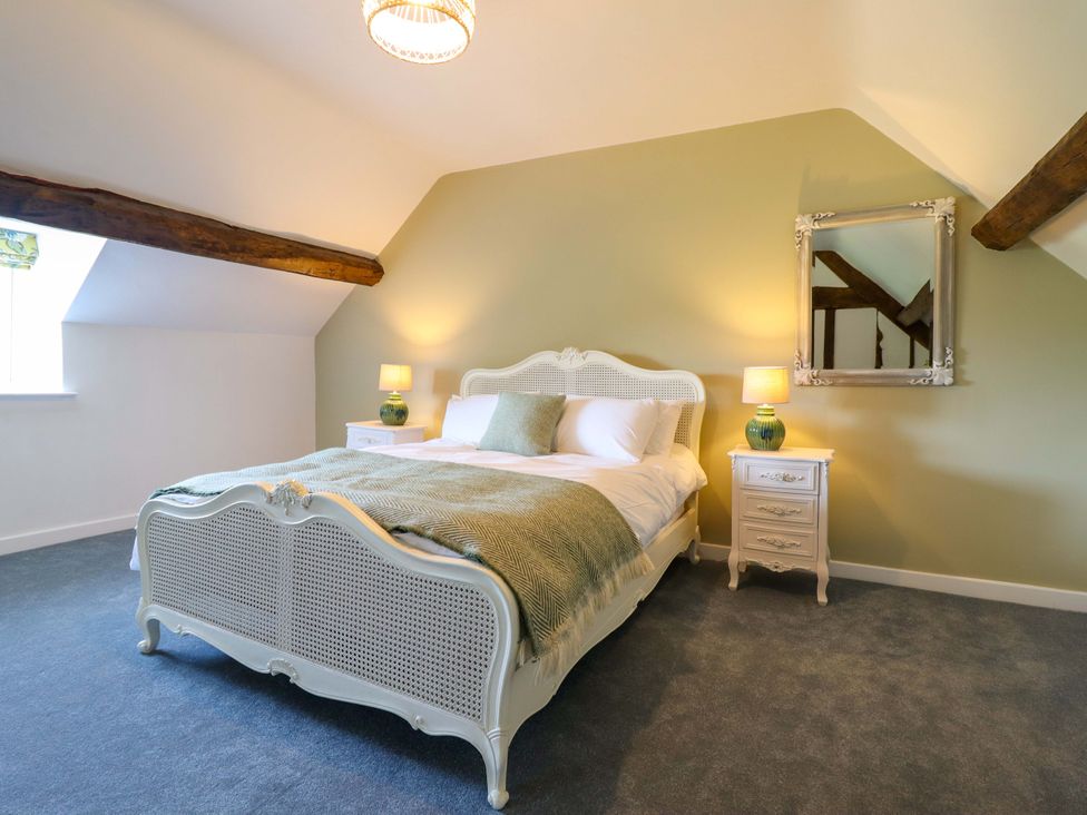 A bedroom with a bed and nightstand at Upper Dolarddyn in Castle Caereinion