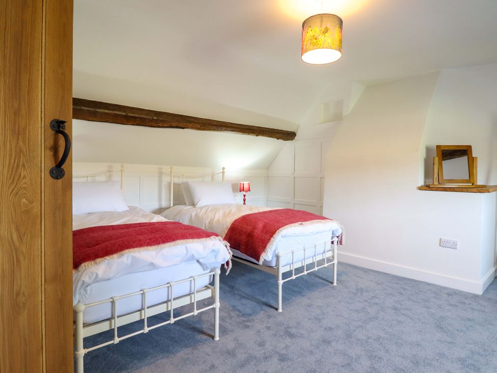 A bedroom with two beds and a lamp at Upper Dolarddyn in Castle Caereinion