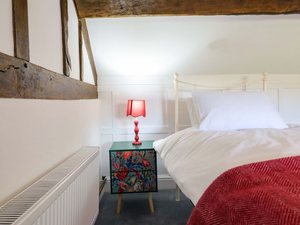 A bedroom with a bed and a lamp on a table at Upper Dolarddyn, Castle Caereinion