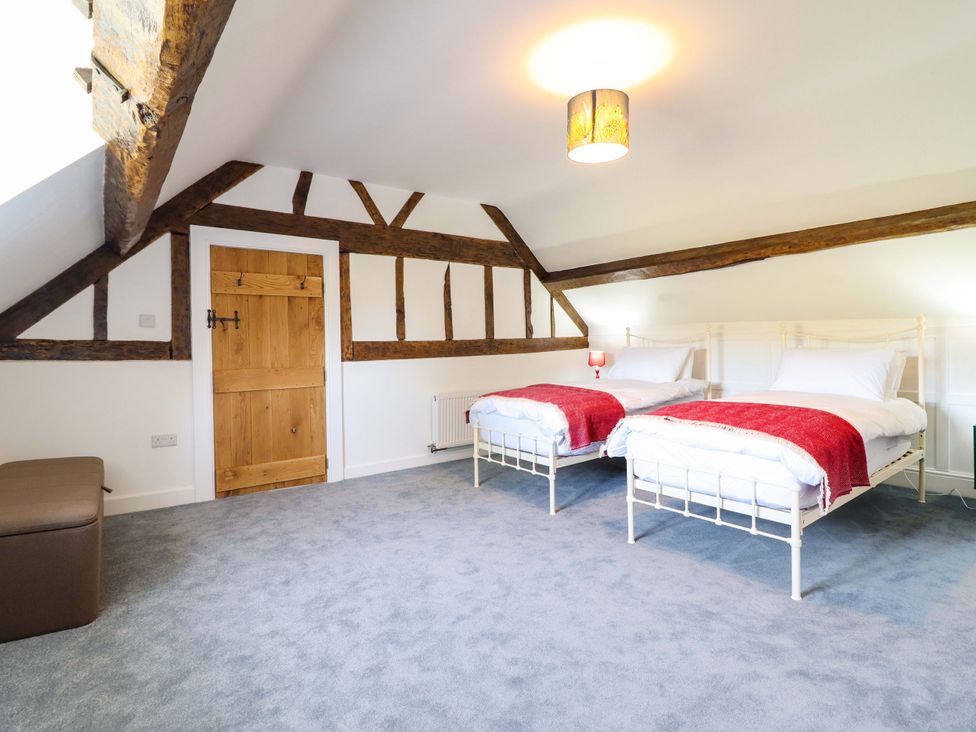 A bedroom with two beds and a wooden door at Upper Dolarddyn Castle Caereinion