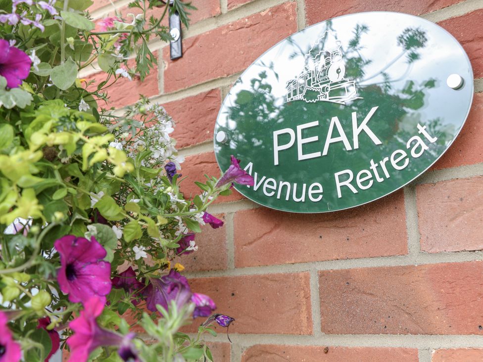 A sign for Peak Avenue Retreat with flowers at Peak Avenue Retreat in Wingerworth near Chesterfield
