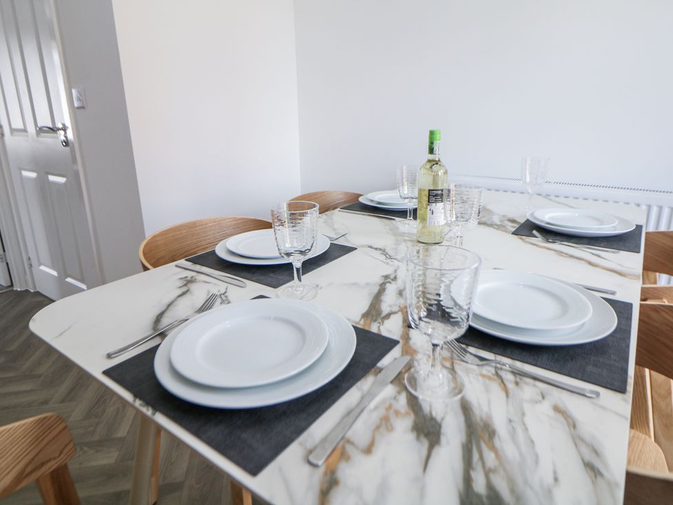 A dining table set with plates and glasses at Peak Avenue Retreat Wingerworth near Chesterfield