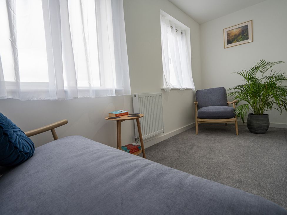 A snug area with a chair and side table at Peak Avenue Retreat in Wingerworth near Chesterfield