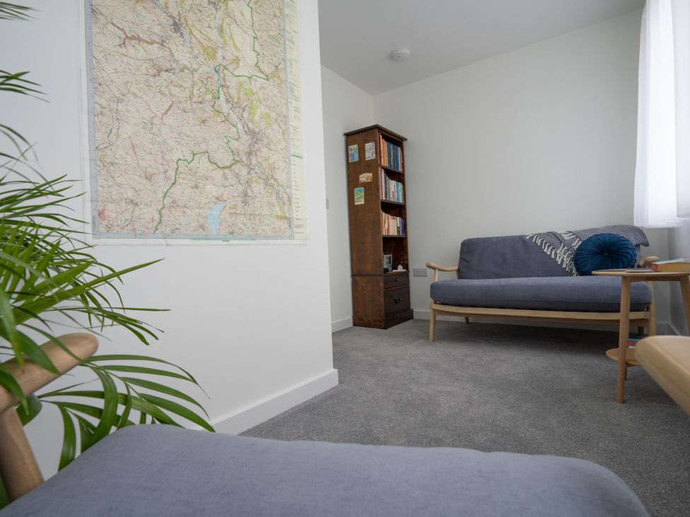 A sitting room with a map on the wall and a bookshelf at Peak Avenue Retreat in Wingerworth near Chesterfield