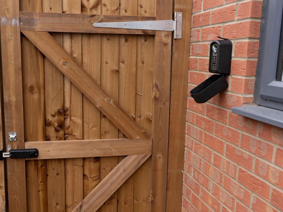 A wooden door with a lock and combination lock on a brick wall at Peak Avenue Retreat in Wingerworth near Chesterfield