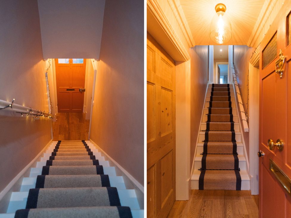 A staircase with a handrail and a front door at Willow Garth Roecliffe near Boroughbridge