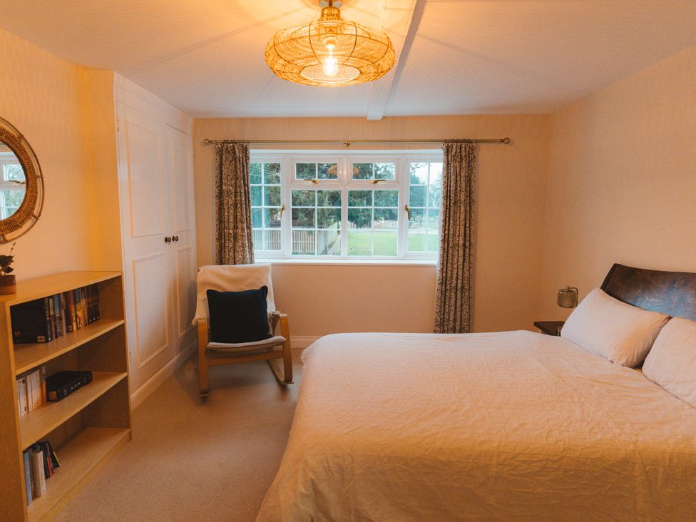 A bedroom with a bed and shelves at Willow Garth Roecliffe near Boroughbridge