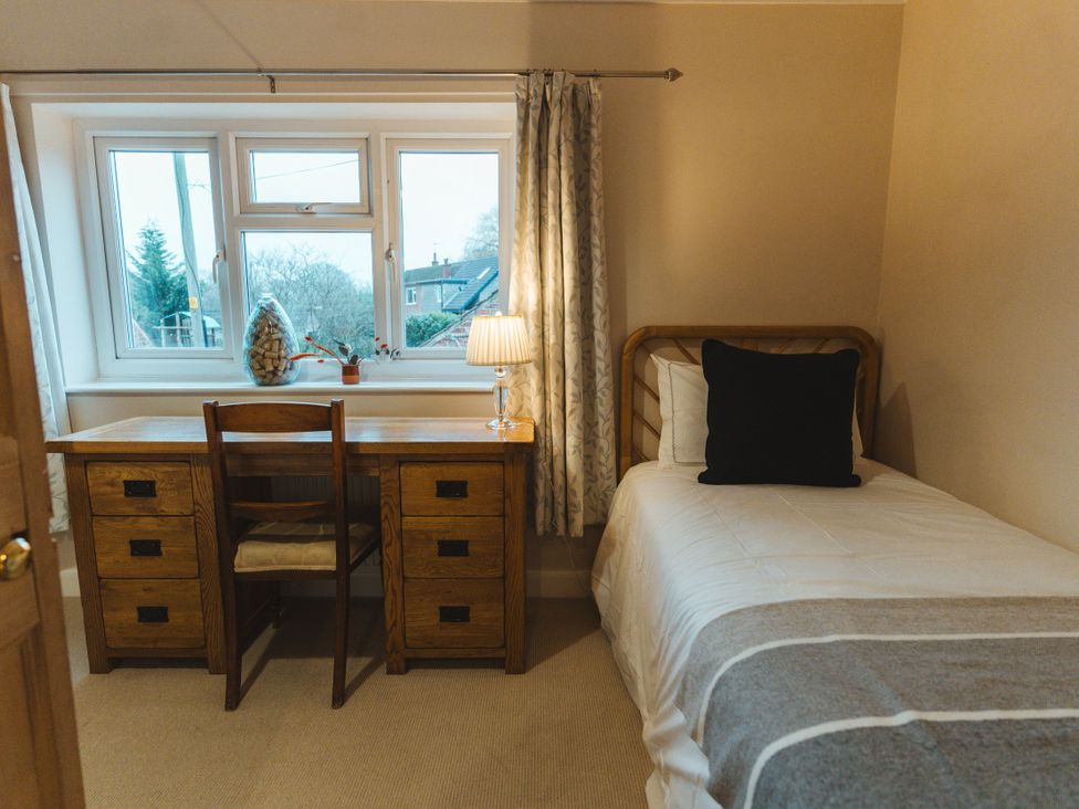 A bedroom with a desk and chair next to a bed at Willow Garth in Roecliffe near Boroughbridge