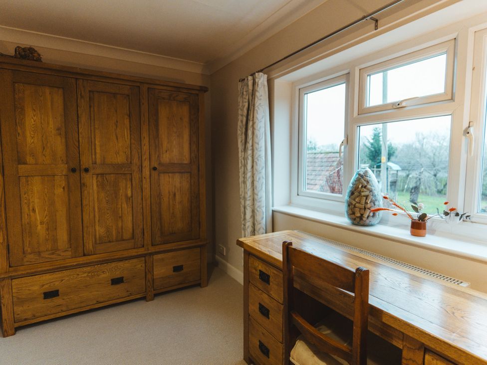 A bedroom with a wooden wardrobe and desk at Willow Garth Roecliffe near Boroughbridge