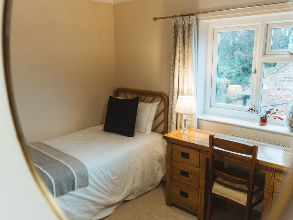 A bedroom with a bed and a desk at Willow Garth in Roecliffe near Boroughbridge