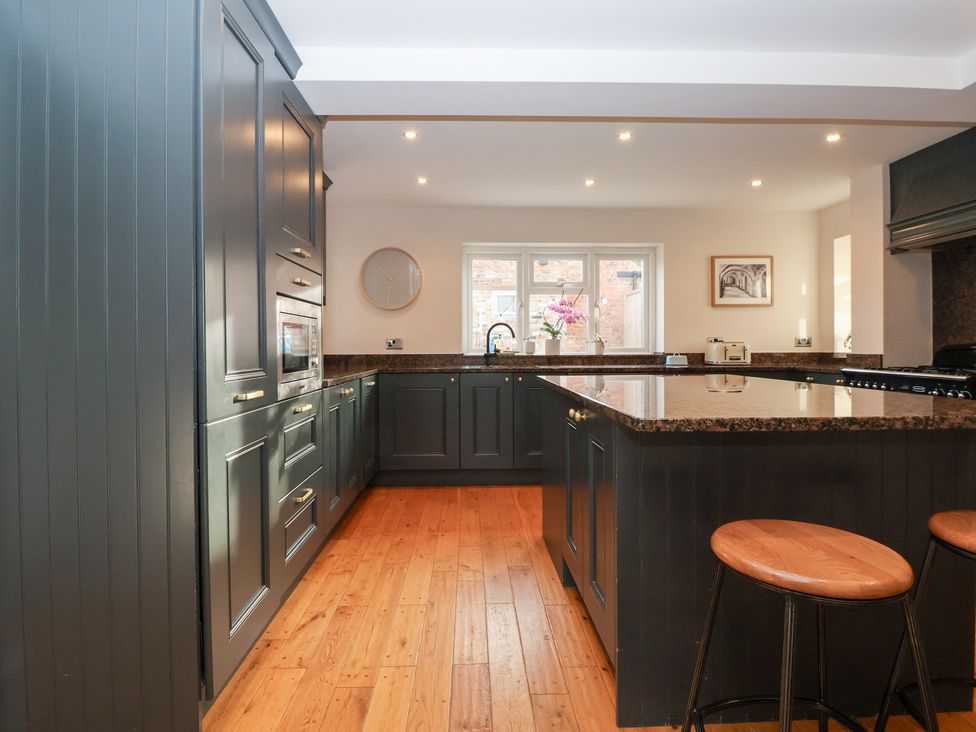 A kitchen with countertop and bar stools at Willow Garth Roecliffe near Boroughbridge