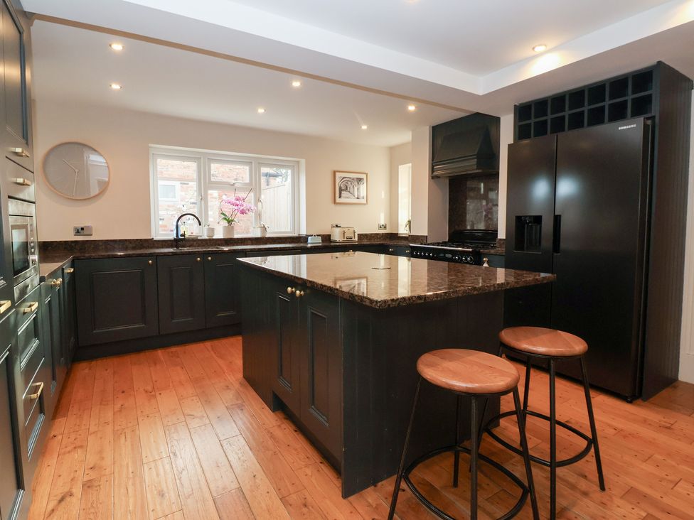 A kitchen with an island and bar stools at Willow Garth Roecliffe near Boroughbridge