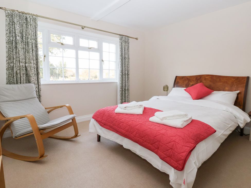 A bedroom with a bed and rocking chair at Willow Garth Roecliffe near Boroughbridge