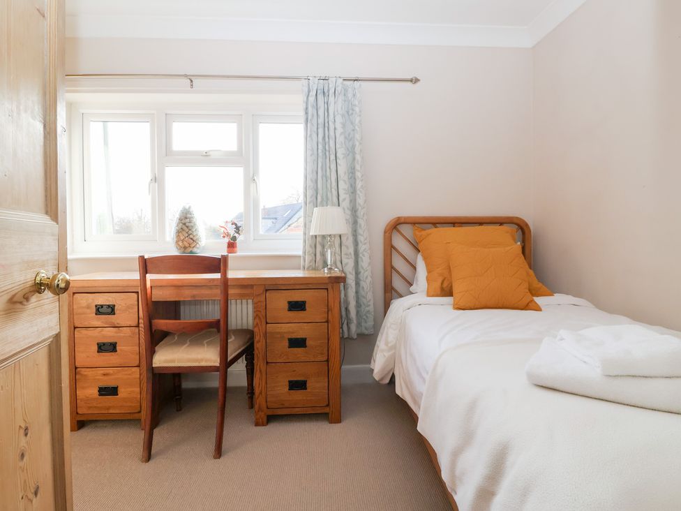 A bedroom with a single bed and a desk with a chair at Willow Garth in Roecliffe near Boroughbridge
