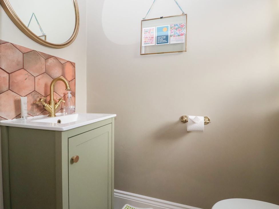 A bathroom with a sink, mirror, and decor at Willow Garth in Roecliffe near Boroughbridge